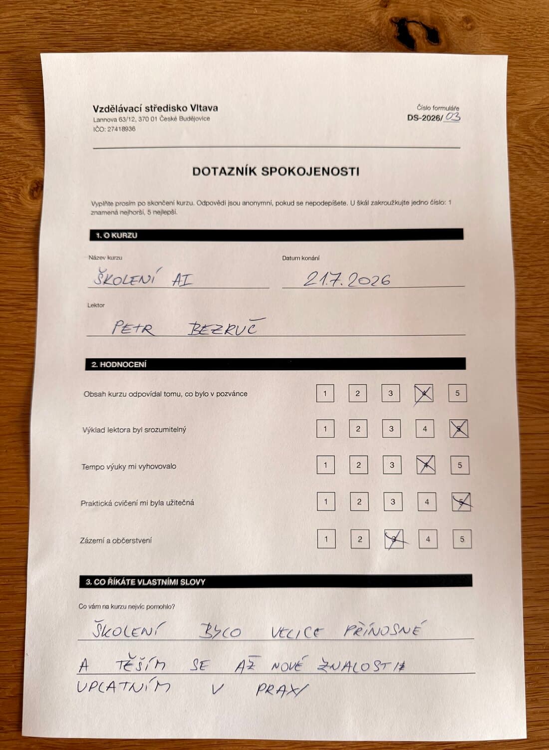 Ručně vyplněný dotazník spokojenosti ze školení, vyfocený na stole. Dvě strany. (1/2)